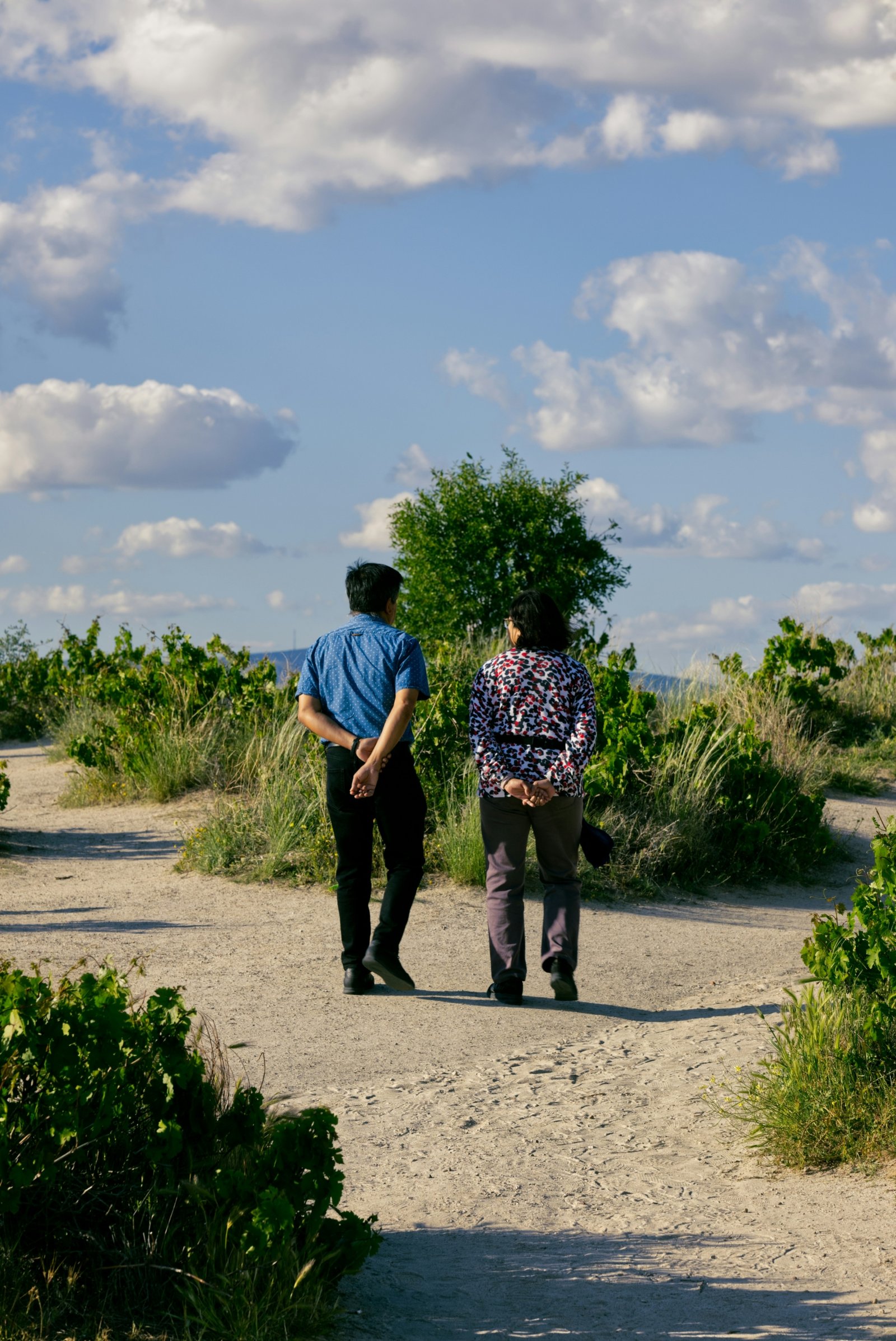 a couple of people that are walking down a dirt road